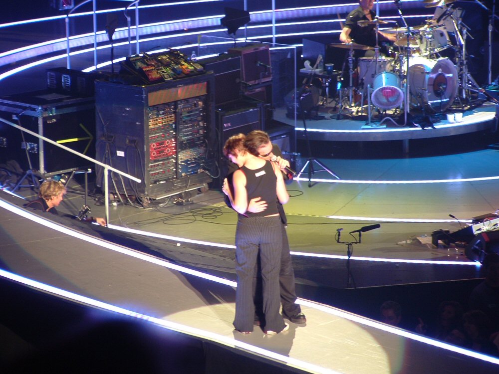 Tara holds onto Bono while Bono sings